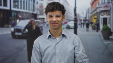 Genç İspanyol adam sessiz kalmak için parmaklarını hareket ettirdi şehir caddesinde bulanık yayalar ve taksiyle; sessiz gizem.