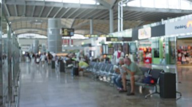 Yumuşak bokeh ve sığ odağıyla bulanık havaalanı içi oturma ve oturma yerini gösteren; arka plan telif alanı sakinliği.