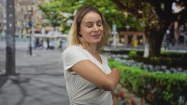 Çapraz kadın kolları sonra meşgul bir şehir caddesinde el sallayarak park çitleri ve asfalt yakın; güven selamlama.