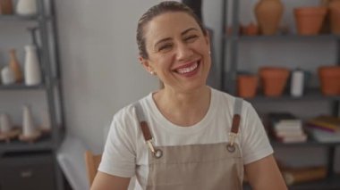 Mutfakta önlük giymiş gülümseyen bir kadın.