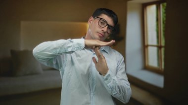 Genç İspanyol adam, çağdaş bir bina odasında mola vermek için iki elini kaldırır..