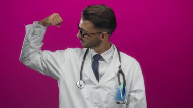 Beyaz önlük ve steteskop giyen İspanyol doktor canlı pembe stüdyoda pazılarını esnetiyor;.