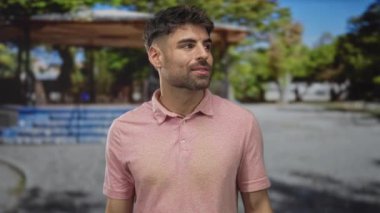 Parlak güneş ışığı altında park köşkü ve yeşil ağaçların yanındaki sokakta el çırpan adam, onaylandı.