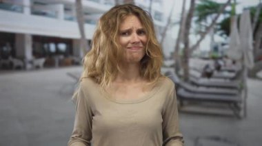 Kadın havuz tesisine giriş yapmayı reddetmek için ellerini kaldırıyor. Tatil hisleri reddedilirken günlük kıyafetlerini giymiş bir sarışının olduğu yere..