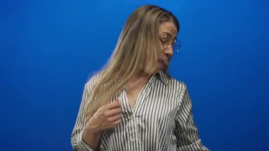 Mavi stüdyoda dans sahnesinde akışkan hareketi yakalayan uzun sarı saçlar atar. Mutluluk enerjisi..