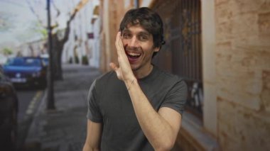 Genç adam, güneşli bir öğleden sonra mavi arabanın yanında bağırmak için kıt kanaat yükseltiyor..