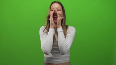 Ağızdan ağıza yumruk atan ve yeşil stüdyoda beyaz bluz giyerek bağıran genç İspanyol kadın, sevinç kutlaması..