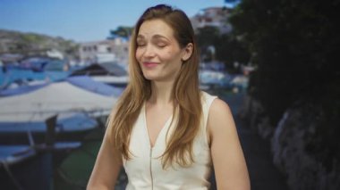 Kafkasyalı genç kadın parlak güneşli gökyüzünün altında tekneyi göstererek sırıtıyor; şüphecilik.