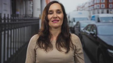 Yoğun caddelerde gülümseyen bir kadın. Etrafı arabalarla çevrili. Gün içinde canlı pozitif enerji ve İspanyol mirası sergiliyor..