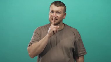 Stüdyoda sessizlik için parmaklar dudaklara görünür parmak ucu ve rahat gülümseme ile işaret eden gizli sessizlik..