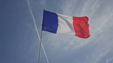 Çatıda rüzgarda dalgalanan Fransız bayrağı, açık gökyüzüne karşı dalgalanan mavi kırmızı üç renk; ulusal gurur..
