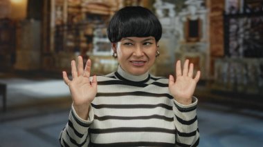 Kilisenin içinde şaşkınlık ve rahatsızlığını ifade eden, çizgili bir süveter giyen, kapalı bir dini mekanda, detaylı mimarisi olan genç bir Çinli kadını ön plana çıkaran bir kadın..