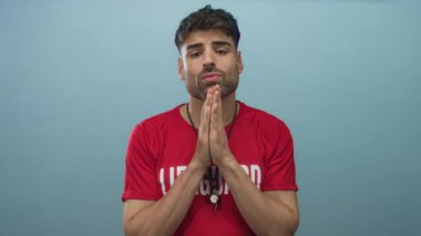 Kırmızı tişörtlü, gümüş düdüklü genç İspanyol cankurtaran mavi stüdyoda el ele tutuşuyor..