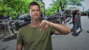 Park halindeki bisikletli ve yeşil ağaçlı bir caddede el ve bilek sallayan adam, eleştiri eleştirmeni görüşü.