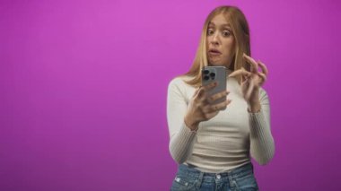 Stüdyoda gülümserken ve selfie çekerken akıllı telefon tutan ve saçlara dokunan kadın; neşeli günlük neşe.