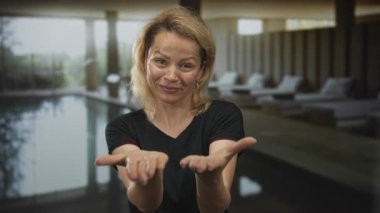 Avuç içi açık sarışın bir kadın bina kaplıcasında kapalı havuz başında dilencilik yapıyor..