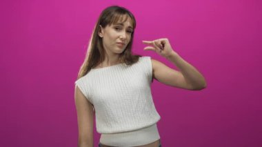 Küçük bir miktar belirtmek için parmaklarını yüze yaklaştıran kadın, stüdyo ortamında parlak pembe arka planla görülebilen el ve ön kol, iğrenme..