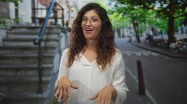 Taş basamakların yakınındaki bir caddede göğsüne işaret eden ve kendine güveni olan bir kadın..