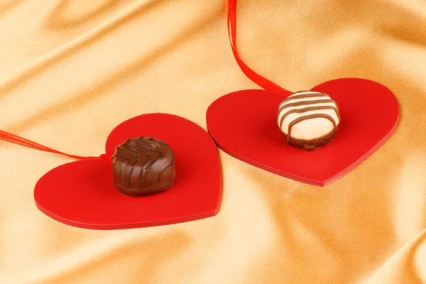 Two chocolate candies and hearts — Stock Photo, Image
