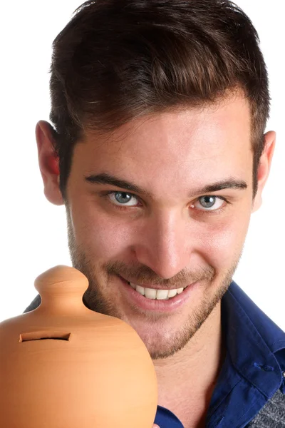 Young man holding a clay moneybox — Stock Photo, Image