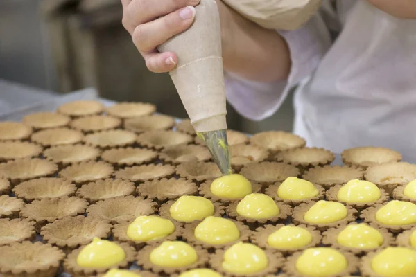 Produção Sobremesas Uma Padaria Profissional Pastelaria Primeiro Plano Trabalhador Segundo — Fotografia de Stock