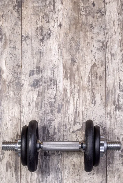 Dumbbell on a wooden background — Stock Photo, Image