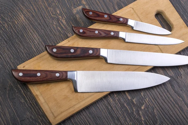 Кухонные ножи на разделочной доске — стоковое фото
