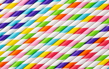 Çizgili içecek pipetlerinin arka planı farklı renklerde