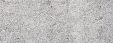 Sert gri beton alçı, eski desenli bir duvar yüzeyi oluşturuyor.