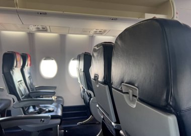 Boş uçak kabini yolcu koltukları ve pencereleri gösteriyor