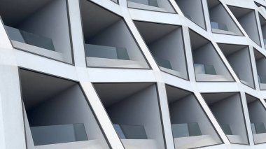 Çağdaş bir tasarım, geometrik desen ve bireysel balkonlara sahip ön cephe