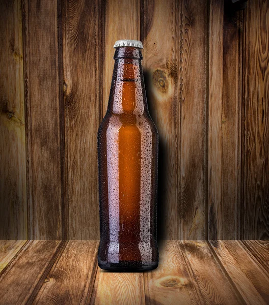 Beer bottle on wooden background — Stock Photo, Image