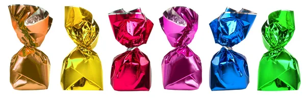 Şeffaf bir arka planda folyo ambalajlı parlak renkli şekerler sunuyor.