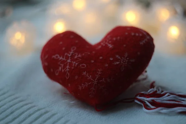 Corazón rojo con copos de nieve sobre un fondo de guirnalda — Foto de Stock