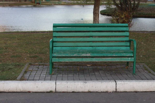 Bir su kütlesinin yanında boş bir park bankı.