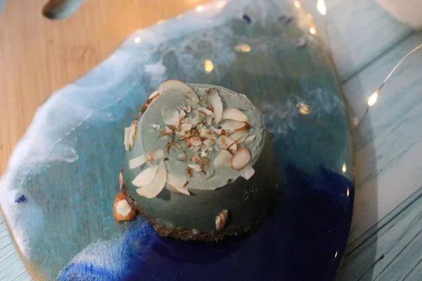 Un vaso con un pastel azul está sentado en una mesa — Foto de Stock