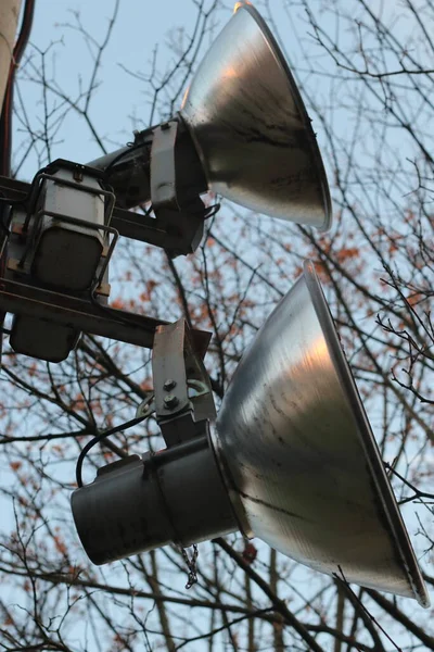 Luidsprekers op een paal tegen een achtergrond van lucht en takken — Stockfoto