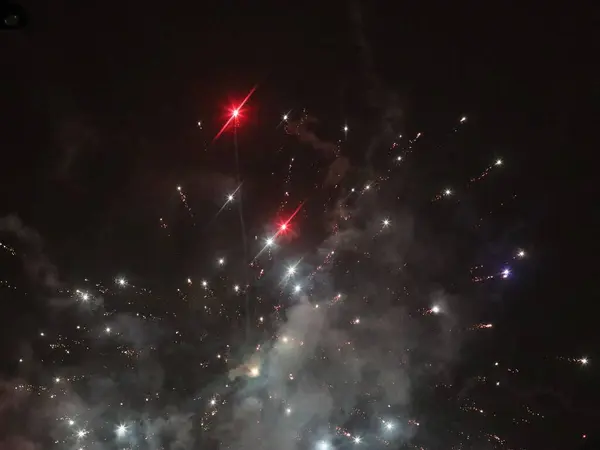 Fuegos artificiales multicolores de año nuevo en el cielo oscuro — Foto de Stock
