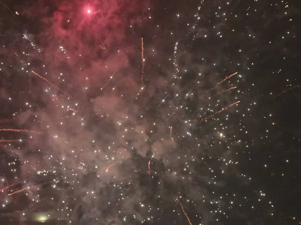 Fuegos artificiales multicolores de año nuevo en el cielo oscuro —  Fotos de Stock