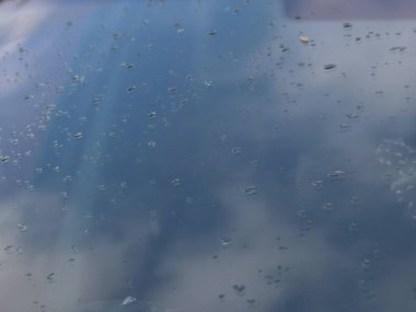 Gökyüzü yağmurdan sonra ön cama yansıdı.