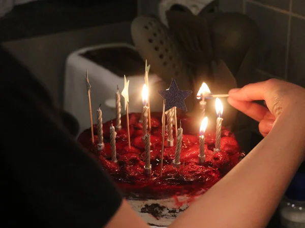 Een persoon die een verjaardagstaart met kaarsen vasthoudt — Stockfoto