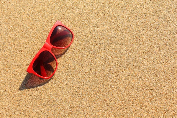 Red sunglasses on the beach — Stock Photo, Image