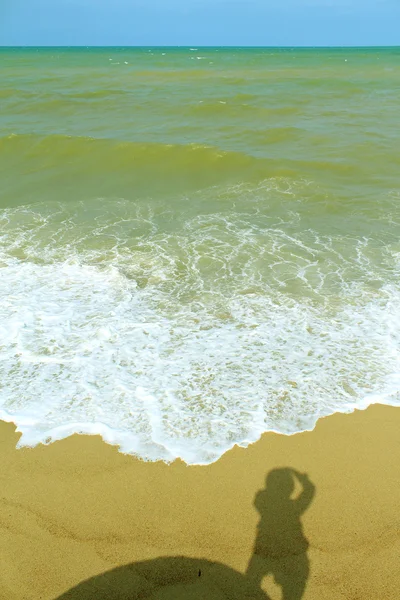 Shadow of the man standing on the sandy beach — Stock Photo, Image