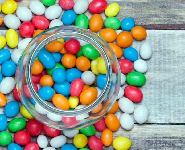 Cam Kavanoz renkli şeker ve tatlılar ile masaya dağınık