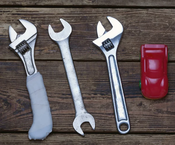 Kleine auto en wrenchs op de planken — Stockfoto