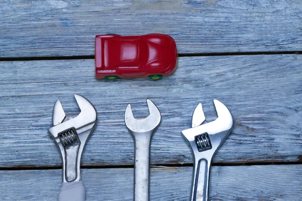 Kleinwagen und Schraubenschlüssel auf lackierten Brettern. — Stockfoto