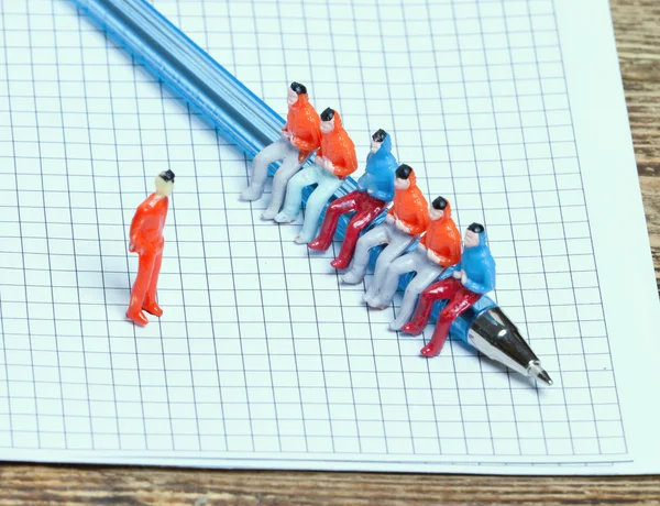 Little people sitting on a pen — Stock Photo, Image