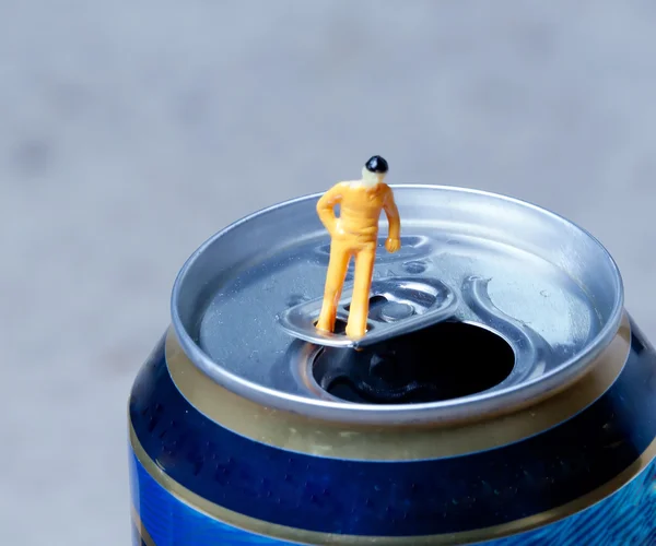 Small man stands in an open aluminum can — Stock Photo, Image