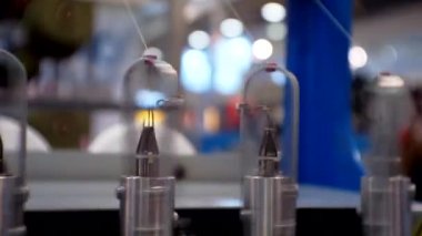 İplikler tekstil makinesinin dönen kısımlarından çekiliyor. Yakın plan..