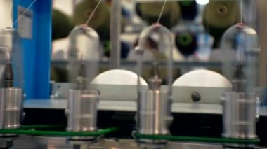 İplikler tekstil makinesinin dönen kısımlarından çekiliyor. Yakın plan..